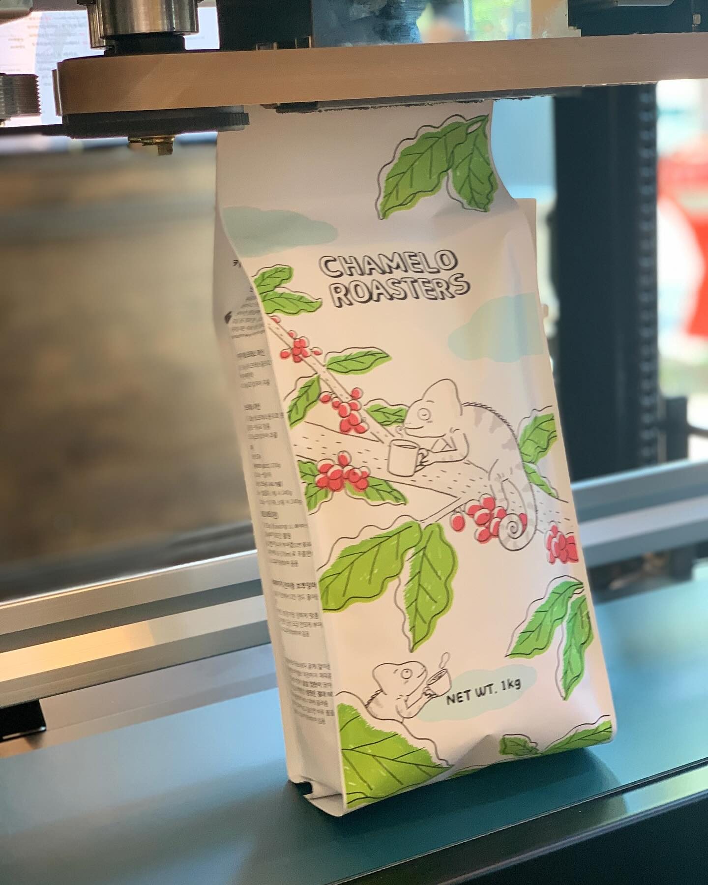 카멜레온과 커피 체리가 그려진 CHAMELO ROASTERS 원두 봉투